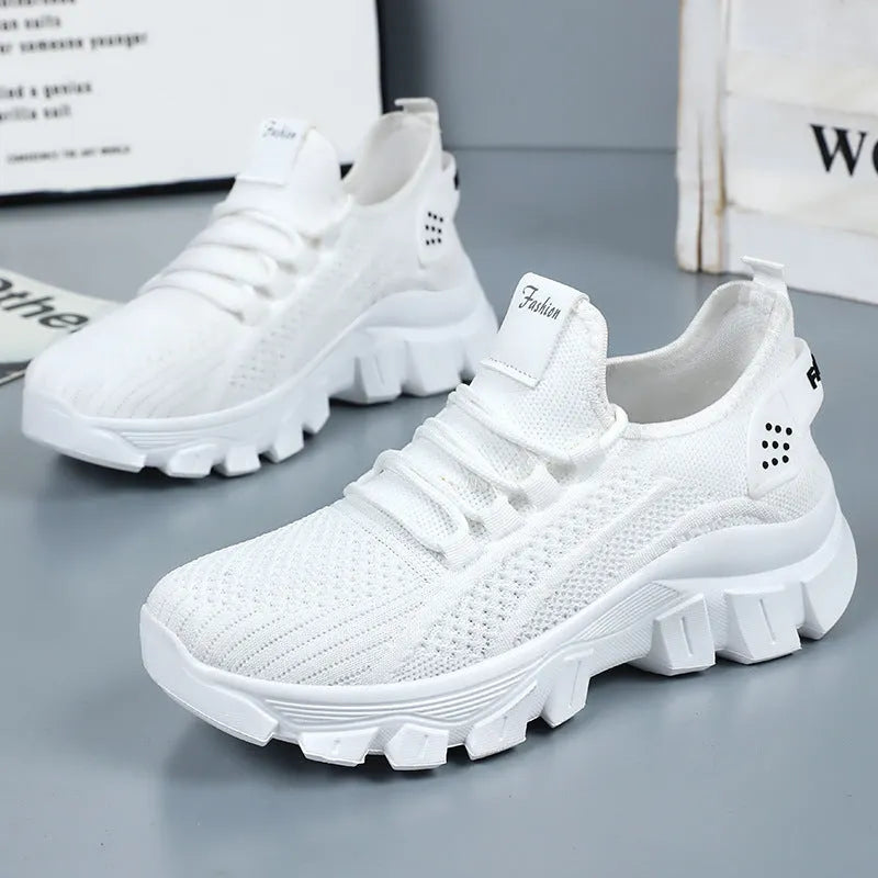 Women's Flyknit sneakers in beige with flat heel, round toe, and lace-up front, showing breathable upper and PVC sole