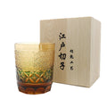 Hand carved Japanese style crystal whiskey glass in amber colour on a dark surface