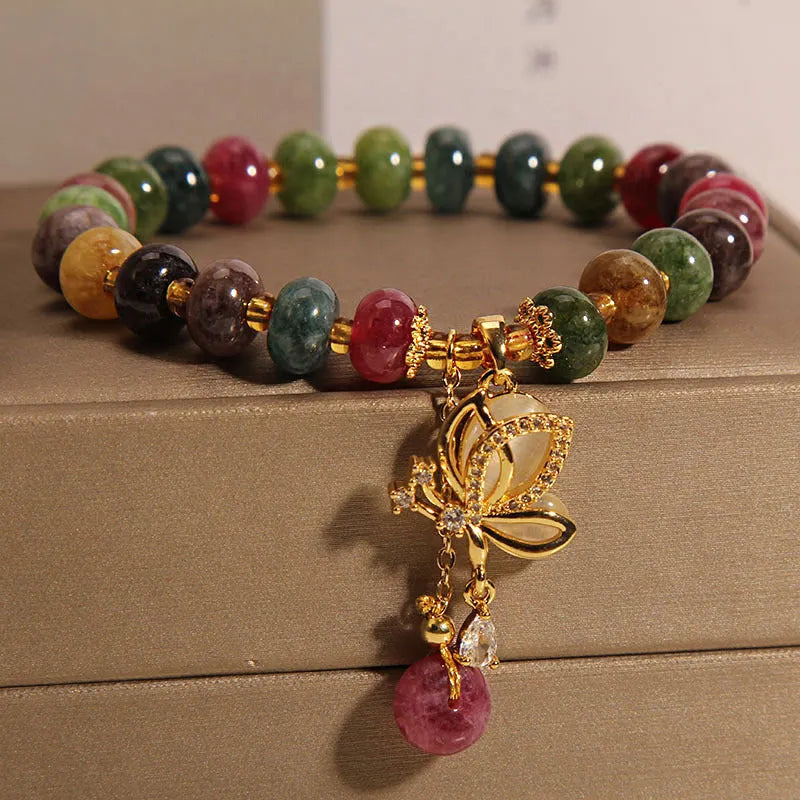 Colourful women's alloy bracelet with multicoloured beads and a butterfly charm on a wrist.