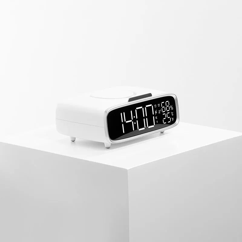 White Bluetooth speaker and wireless charging pad with integrated colour-changing night light on a bedside table.
