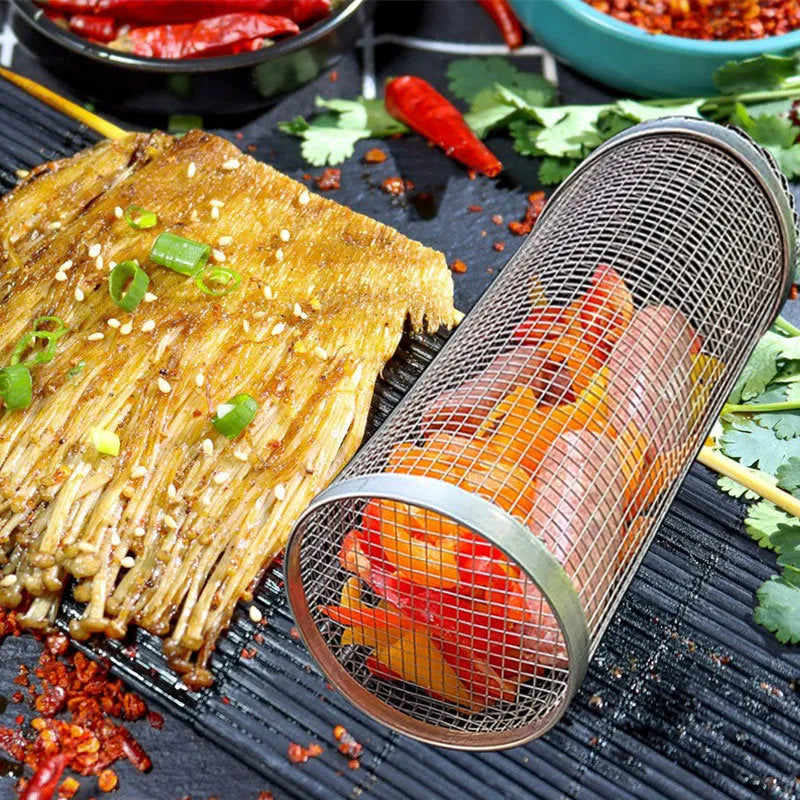 Stainless steel cylindrical rolling grill basket for BBQ with wire mesh, shown with vegetables inside.