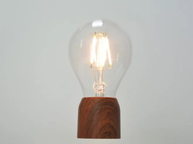 Magnetic levitation bulb floating above imitation wood base with ABS and glass construction, EU CE certified for 100-240V operation