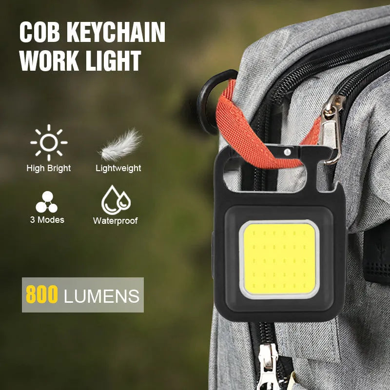 Black aluminium alloy keychain light with magnetic base and foldable handle, measuring 6 cm by 4.2 cm