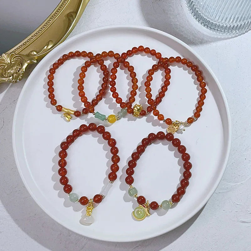 Women's handcrafted red agate bracelet with Chinese dragon design and lucky charm elements