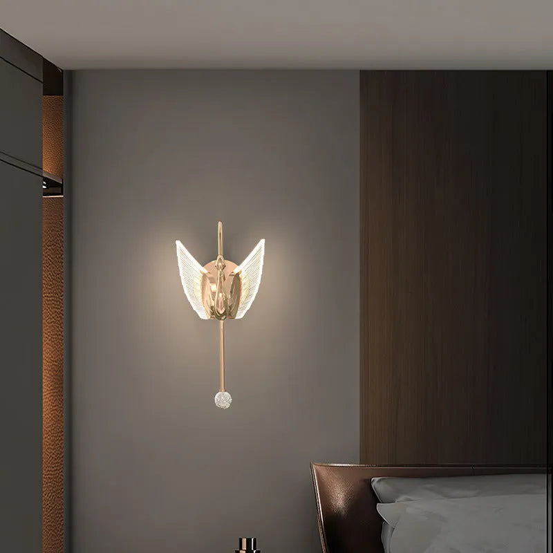 Gold swan-shaped wall lamp with acrylic shade and iron body, mounted beside bed with adjustable LED lighting