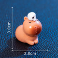 Set of eight small Halloween-themed capybara resin figurines on a wooden surface.