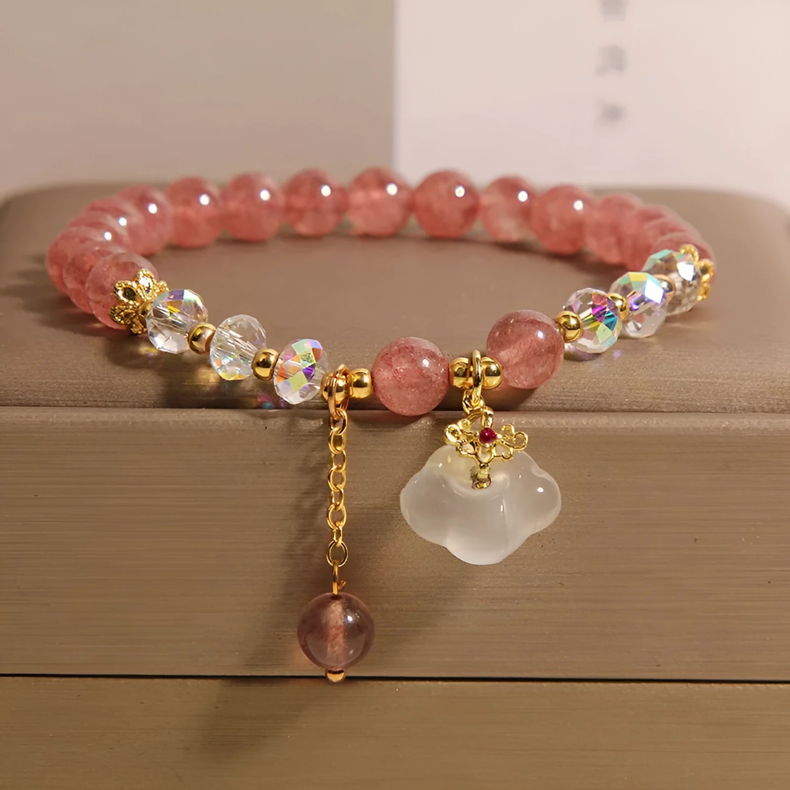 Women's strawberry quartz and white agate crystal bracelet with auspicious clouds charm.