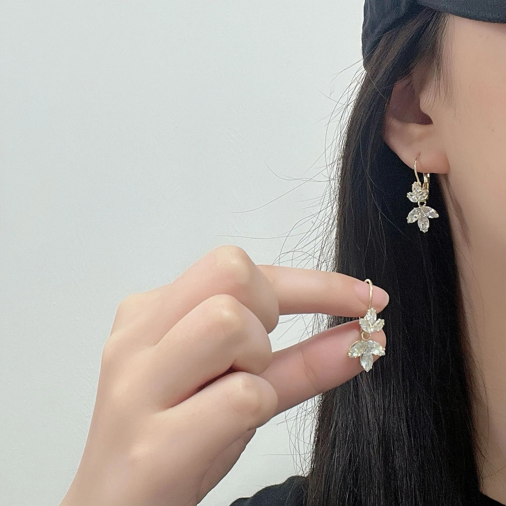 A pair of platinum-coloured alloy earrings in a leaf shape with an inlaid zircon shiny finish.