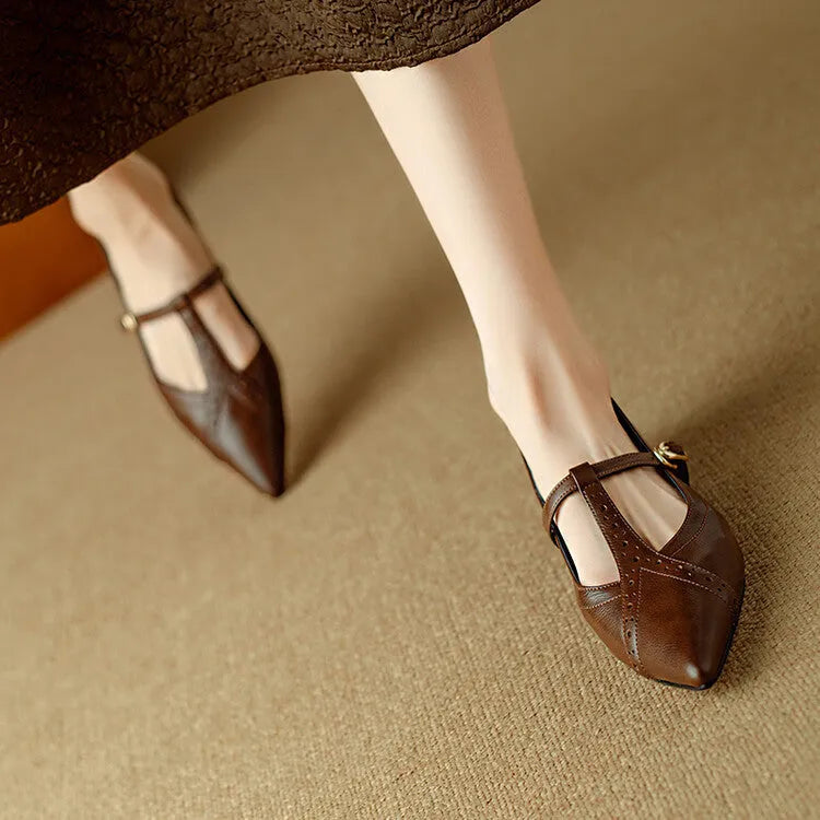 Brown women's rounded toe cowhide flat shoes with a low heel on a neutral background.