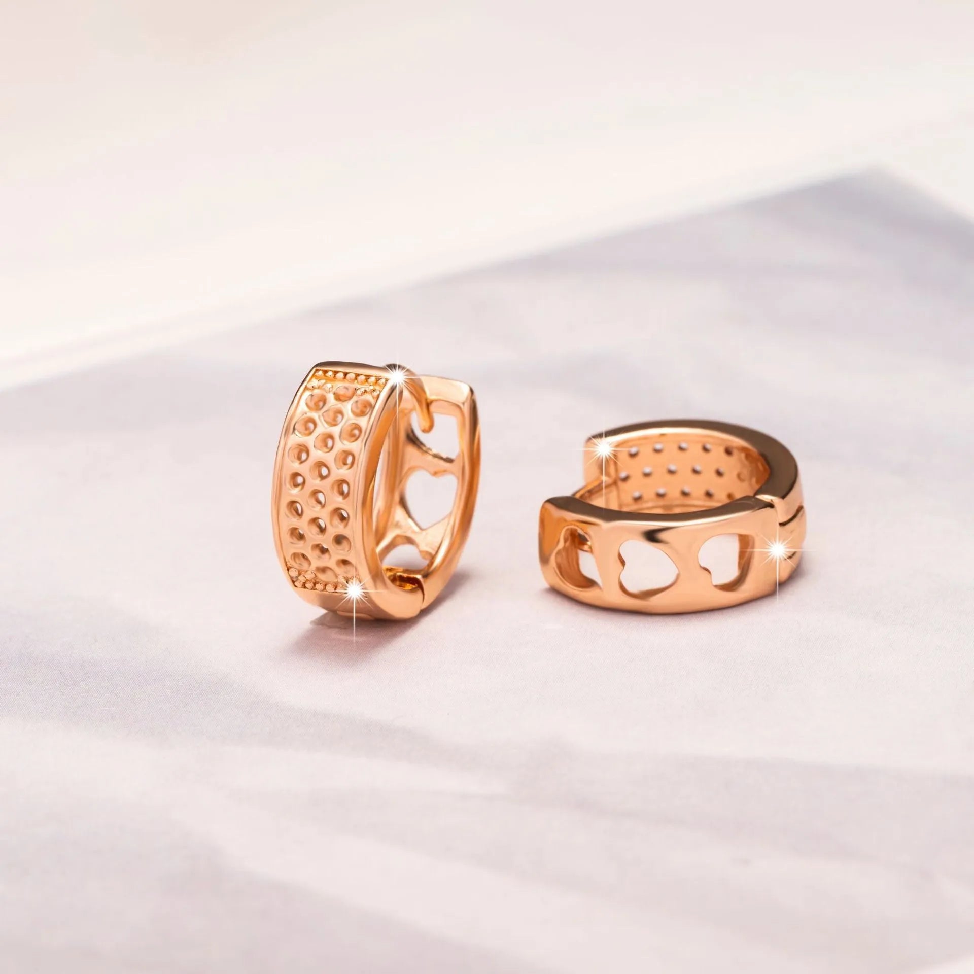 Rose gold hollowed-out heart earrings with circular 2.5cm diameter on white background