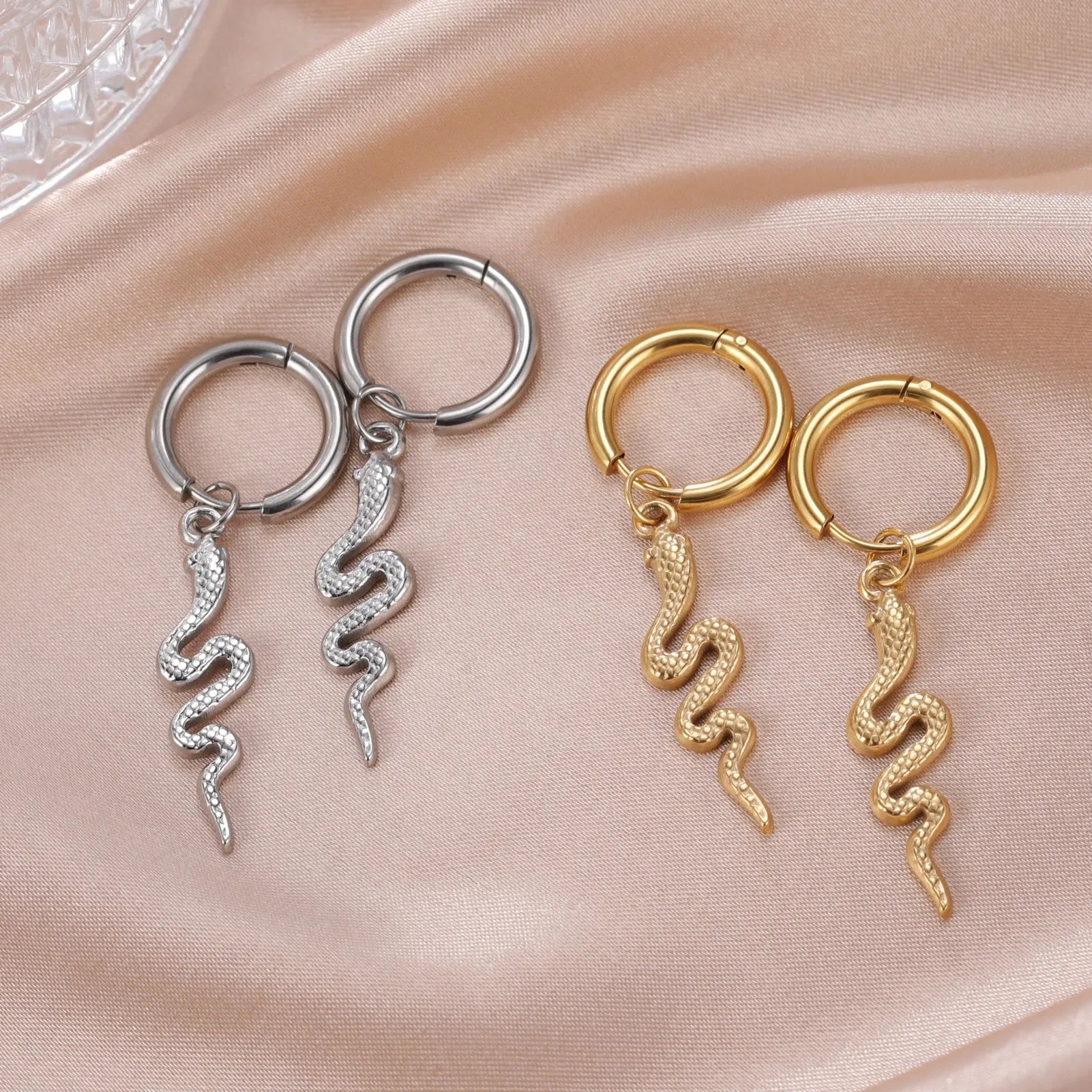 Gold plated stainless steel snake-shaped vintage earrings with detailed scale patterning and clip back closure