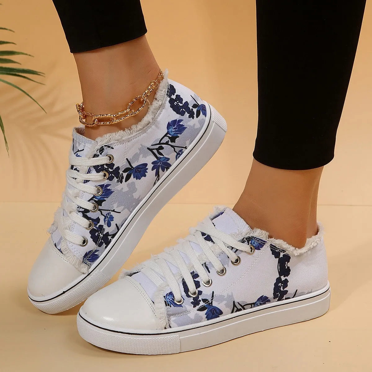 Women's flat canvas shoes with flower print, lace-up front, low-top design, and rubber sole in white green twig and denim colours.