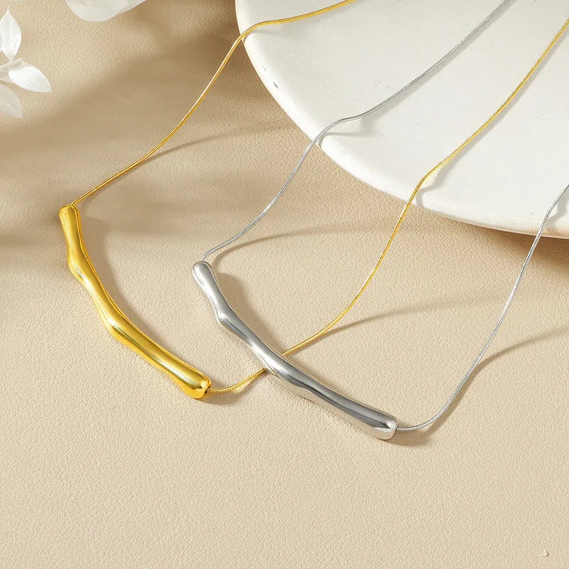 Close-up of a women's titanium steel necklace with an irregular pleated texture, shown in a gold tone finish.