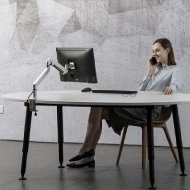 Silver aluminium alloy laptop stand with adjustable height and 360-degree rotation on a wooden desk