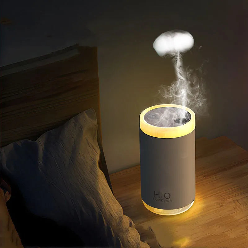 White jellyfish humidifier with blue lighting on wooden table showing mist emission