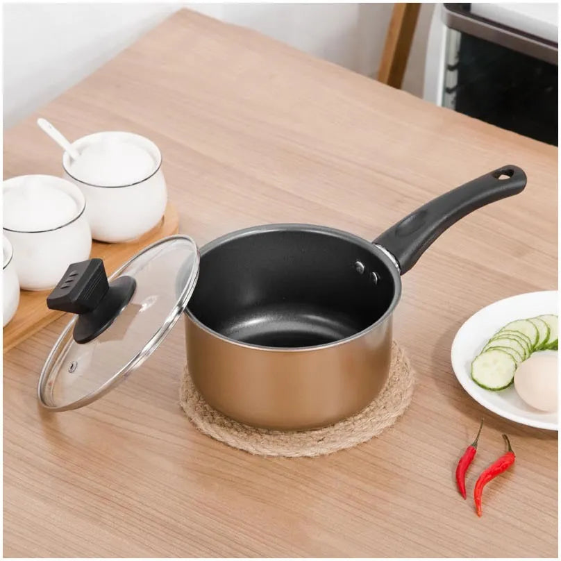 Cast iron three-piece cookware set with soup pot, milk pot, and wok on a kitchen counter
