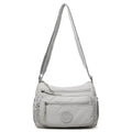 Soft water-repellent nylon crossbody bag in grey with a front 3D pocket.