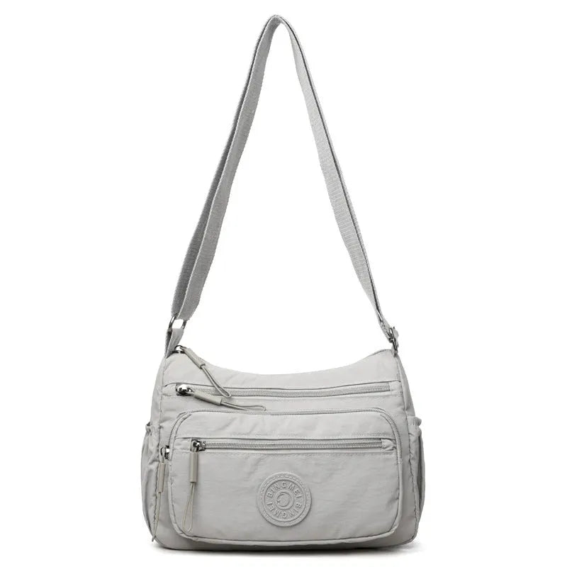 Soft water-repellent nylon crossbody bag in grey with a front 3D pocket.