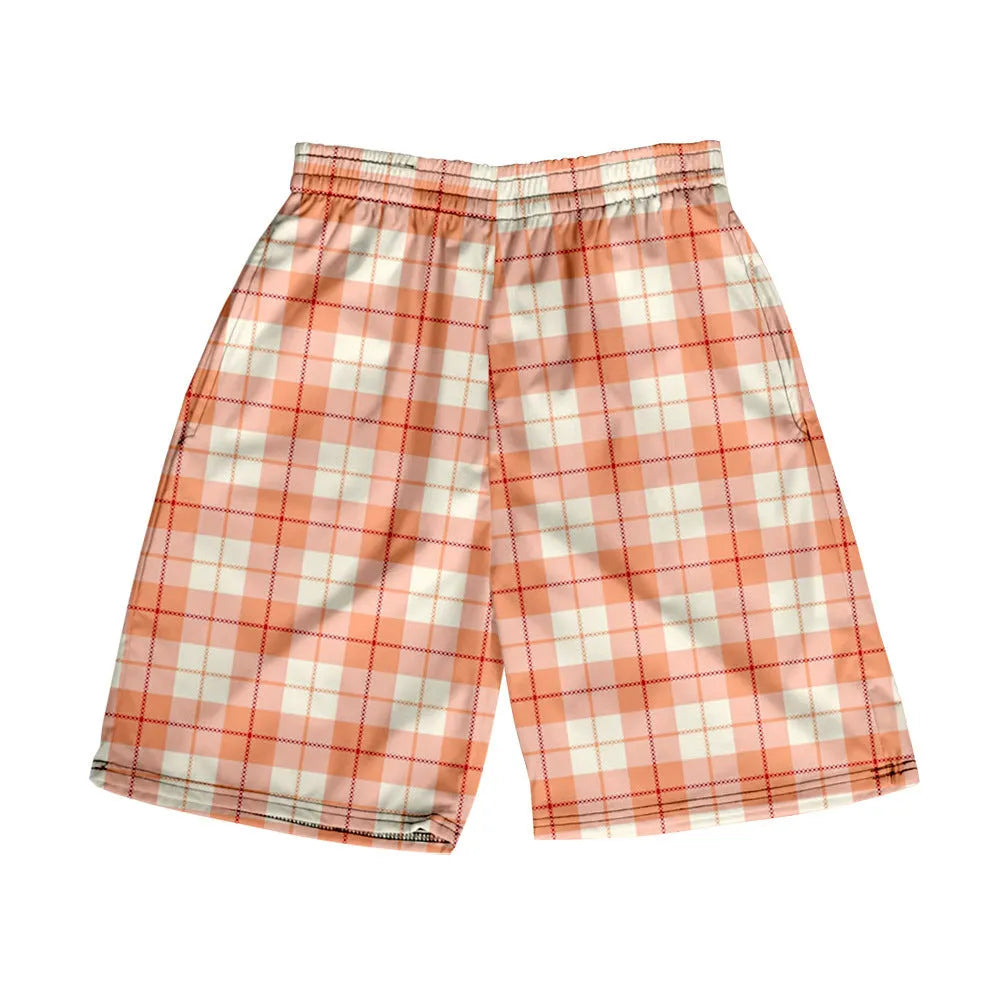 Man wearing grey plaid casual shorts with an elastic waistband, on a beach.