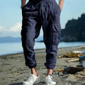 Men's loose-fit linen trousers with ankle ties and multiple pockets in solid colours