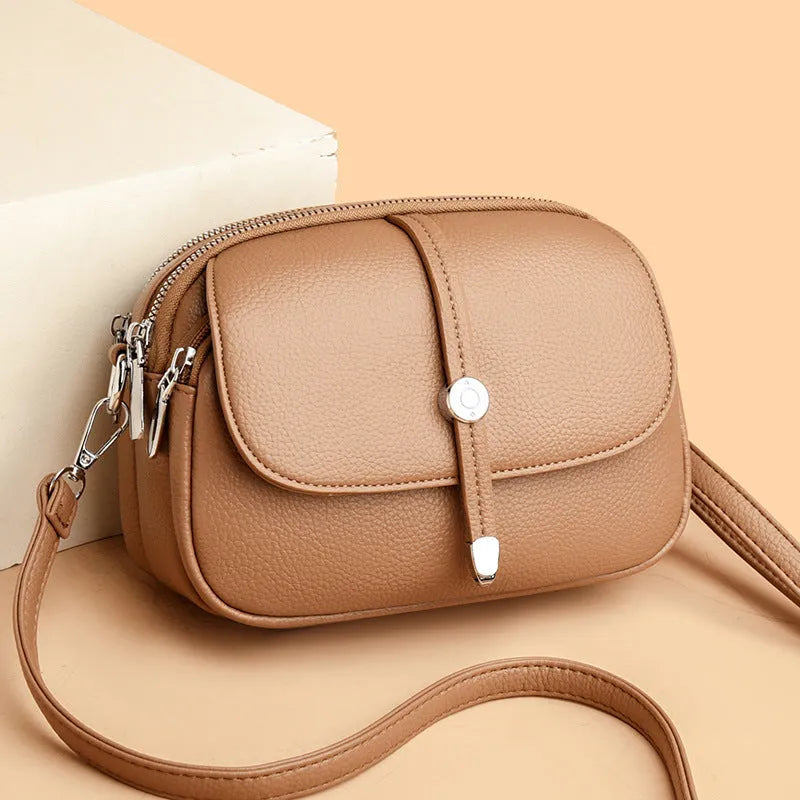 Women's soft PU oval crossbody shoulder bag with sewing thread detailing in dark brown