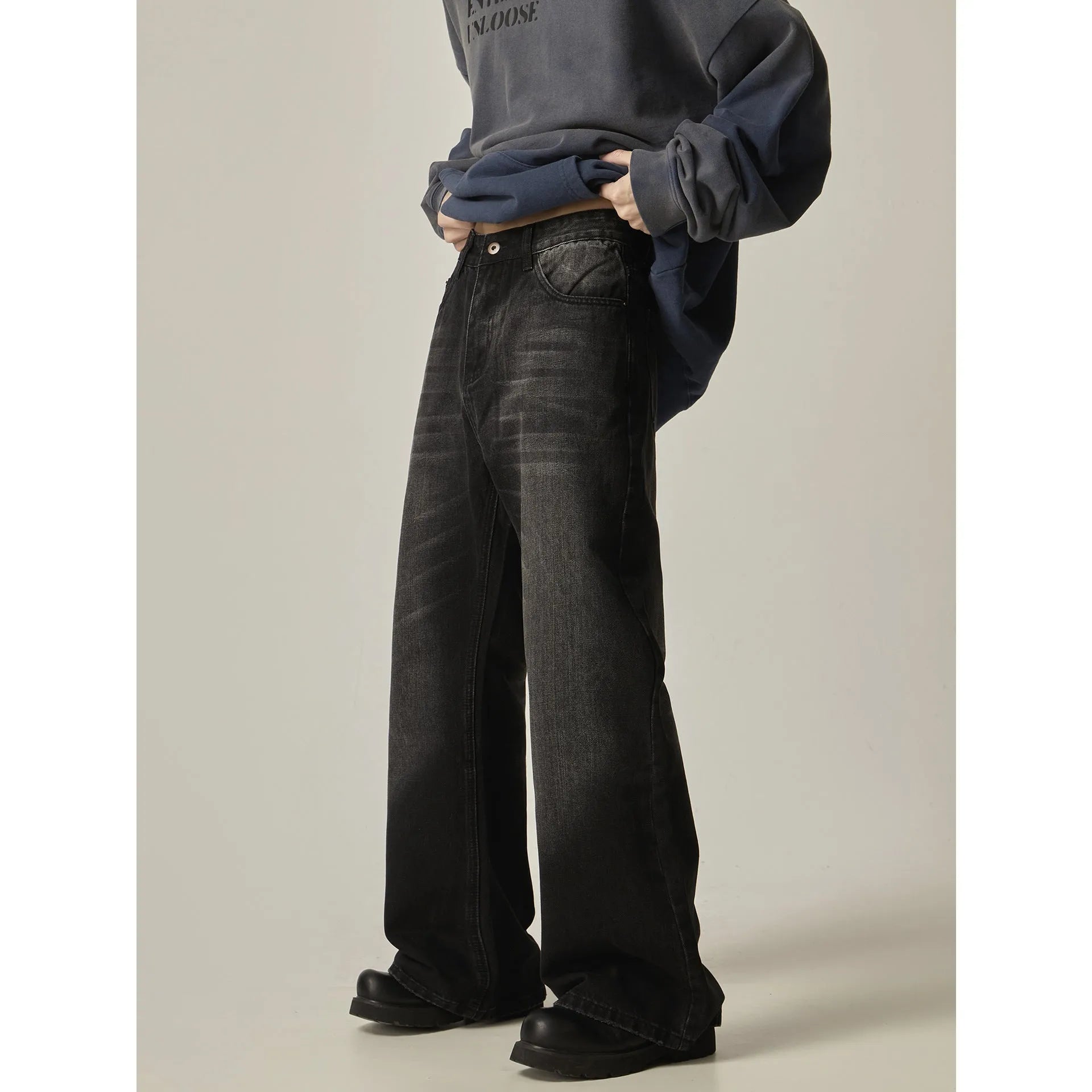 Black loose straight leg jeans with inelastic denim fabric and zipper fly closure