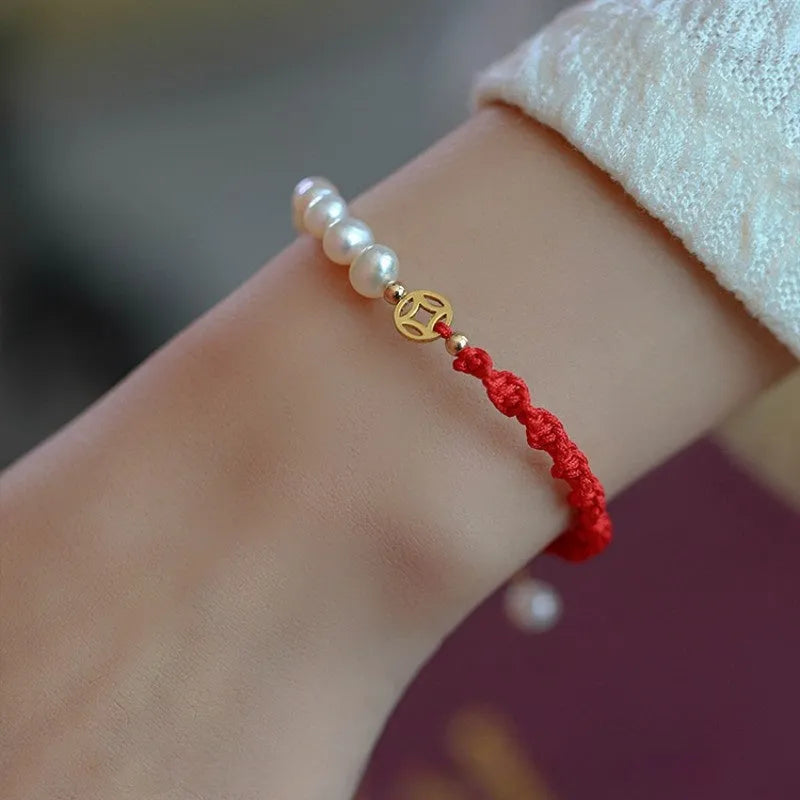 Women's pearl bracelet with braided red rope and gold plated fu character charm