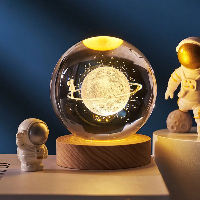 3D crystal ball night light projecting starry sky and planets from its 6cm sphere on a solid wood base.