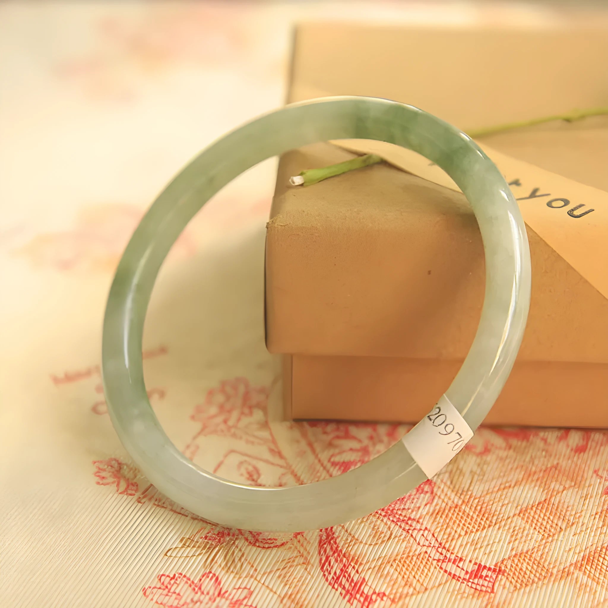 Green jade waxy geometric bracelet with Chinese design elements on wrist