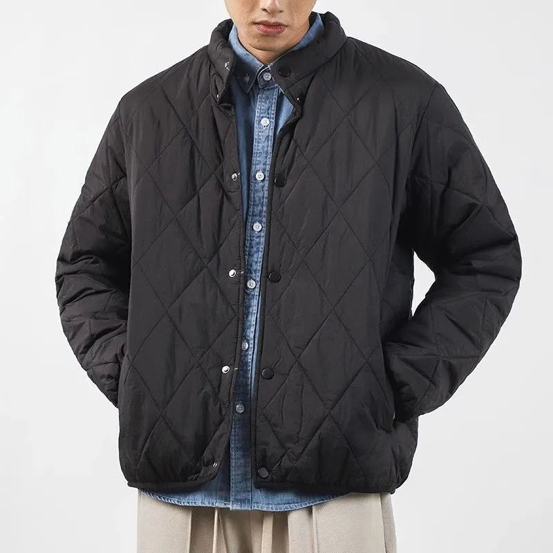 Man wearing a long black diamond quilted padded winter jacket with a loose fit.