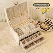Leather jewellery storage box with three drawers open, showing storage for necklaces, earrings, and bracelets.