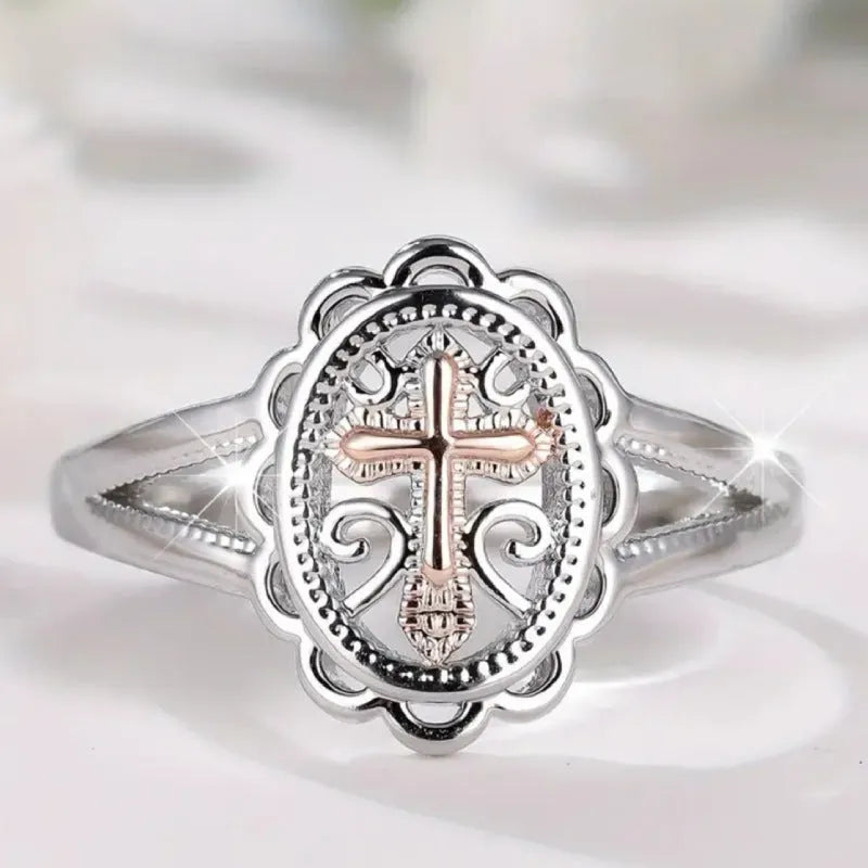 Silver coloured women's ring with a detailed cross charm featuring a lace pattern.