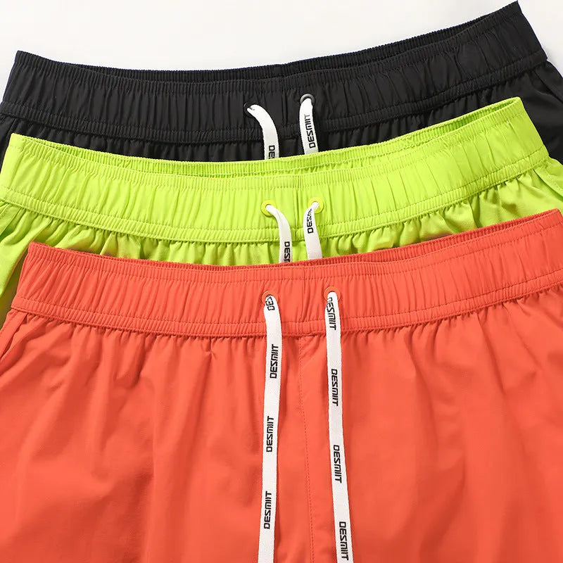 Men's loose beach surfing shorts in orange, fluorescent green, or black with elastic waistband and micro-elastic fabric