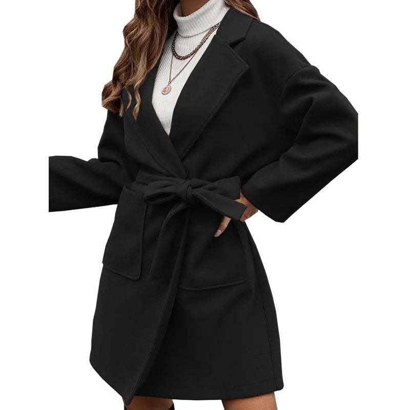 Minimalist long sleeve lapel coat with a split belt in a light blue colour, shown on a model.