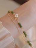 Natural olivine bracelet with double layer design featuring twin bells and olive branch motif