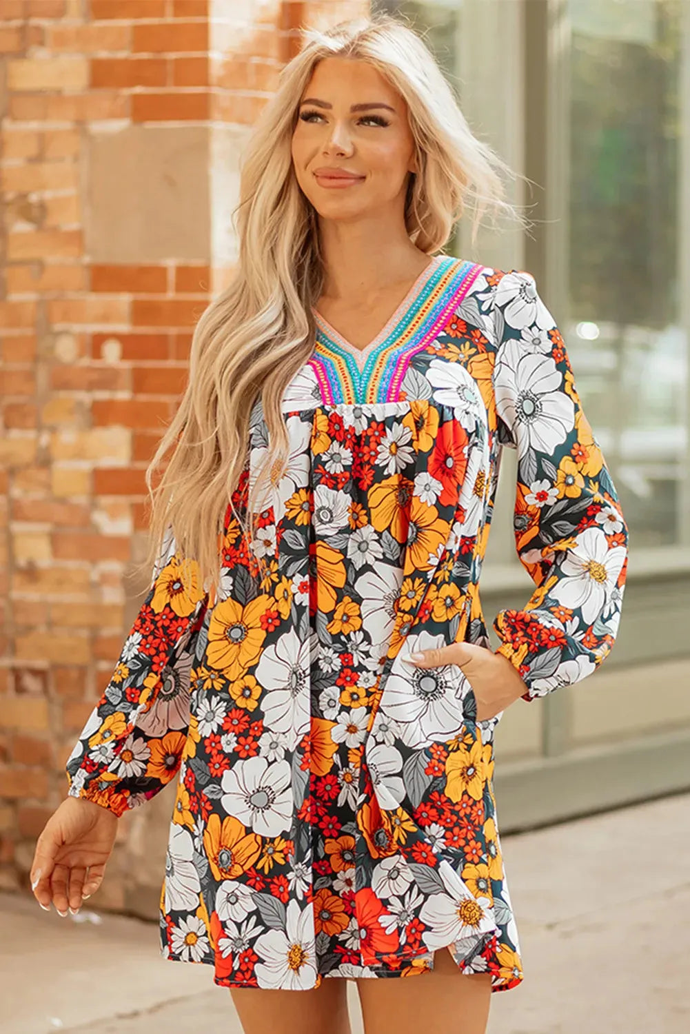 Orange floral and striped print long sleeve V-neck mini dress with lace detail on hanger.