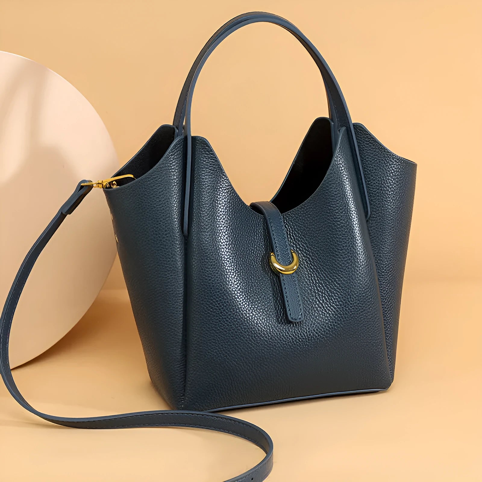 Genuine leather women's retro bucket handbag in beige with sewn detailing and an outer pocket.