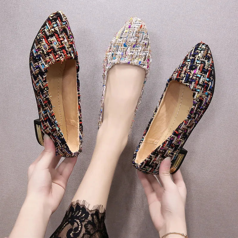 Women's black and white floral patterned canvas casual shoes with a pointed toe and flat rubber sole.
