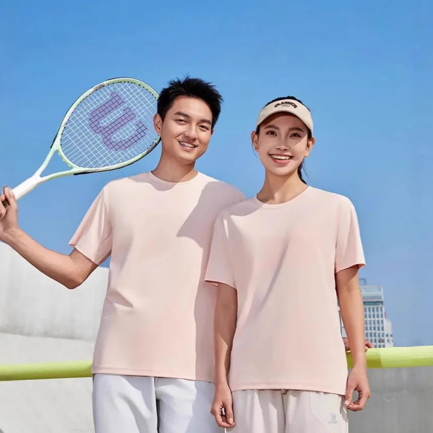 Men's loose fit solid colour polyester sports t-shirt on a hanger, shown in coral pink.