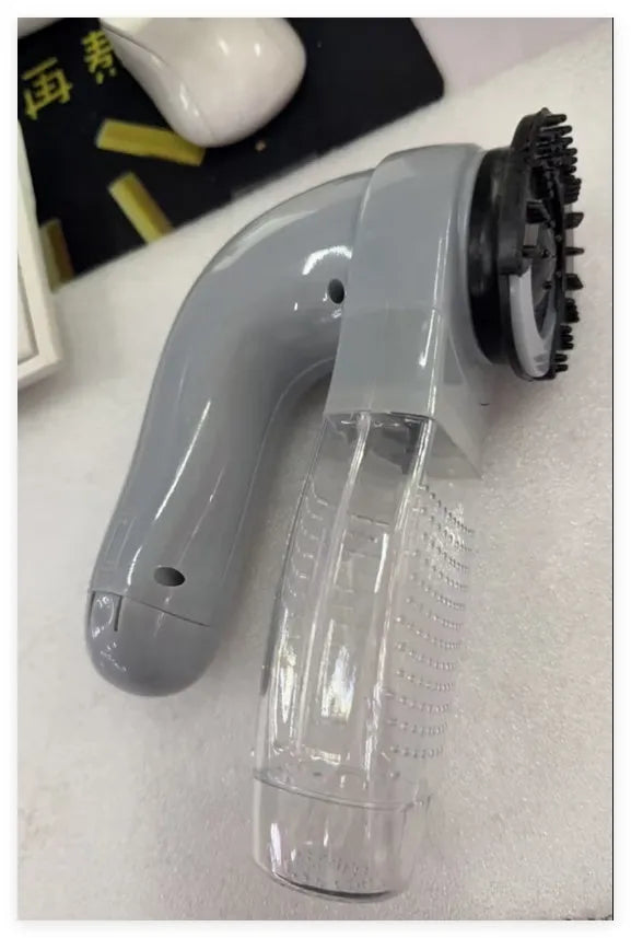 Grey portable pet hair vacuum cleaner and massage brush for dog and cat grooming on sofa