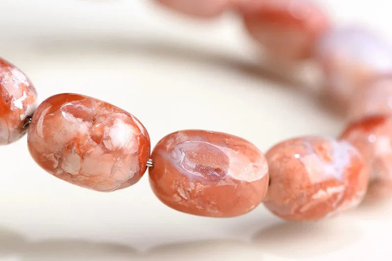 Natural cherry agate barrel shaped bead bracelet showing 10x14mm geometry design with Ruyi elements on wrist