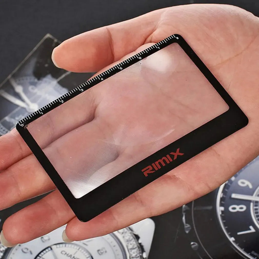 A black and white portable credit card sized plastic magnifier with 6x magnification for outdoor use.