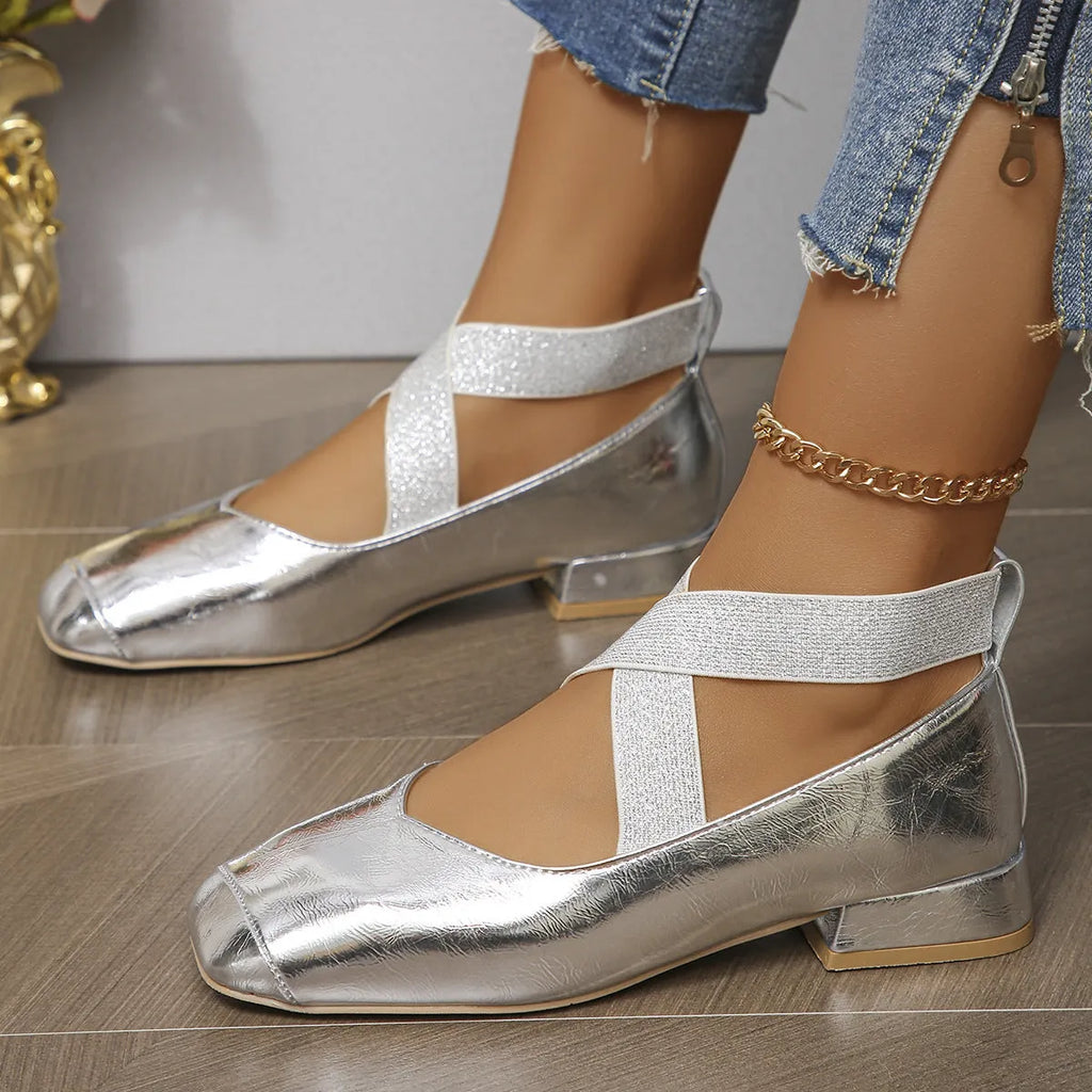Gold slip-on evening pump with square toe and low rubber heel on a white background