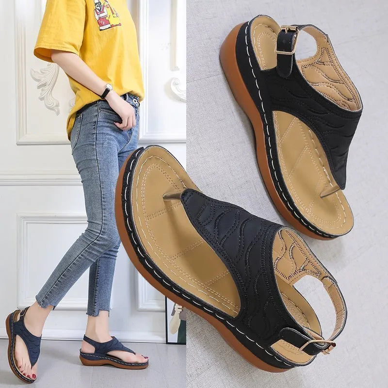 Women's casual wedge heel flip flop sandals with an adjustable buckle strap on the back, shown in a solid colour.