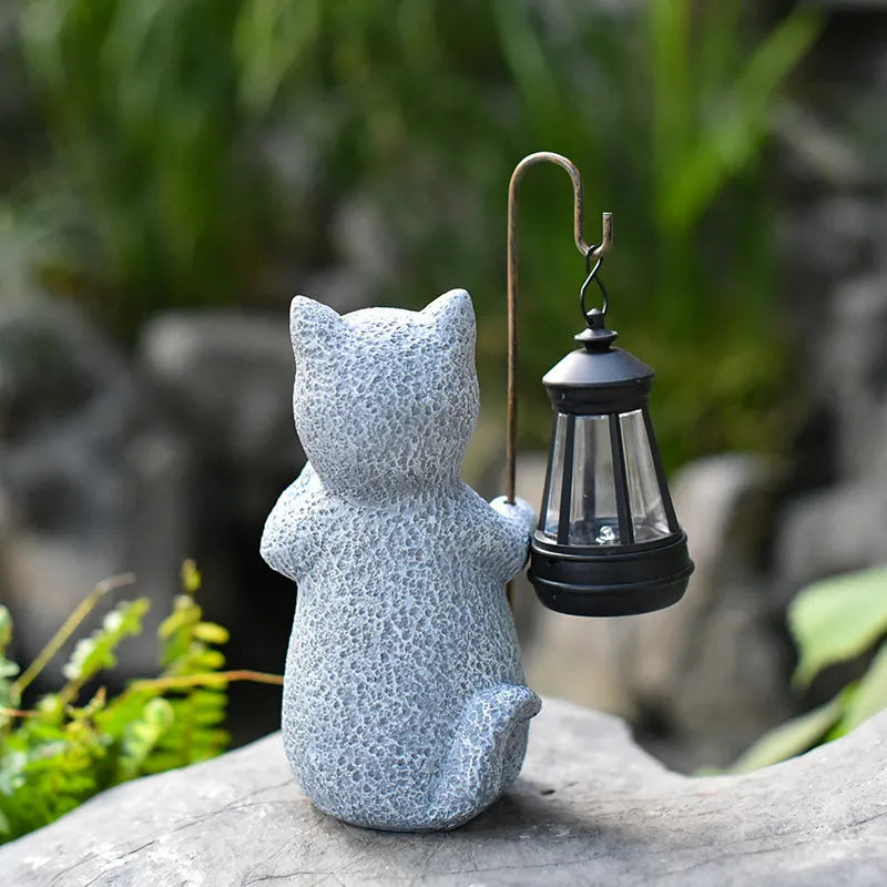 Solar garden light featuring a resin sculpture of a kitten holding up a lantern.