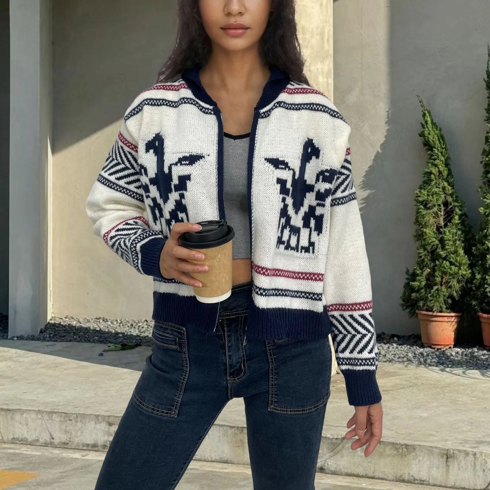 White women's zip cardigan with a contrasting striped jacquard lapel on a hanger.