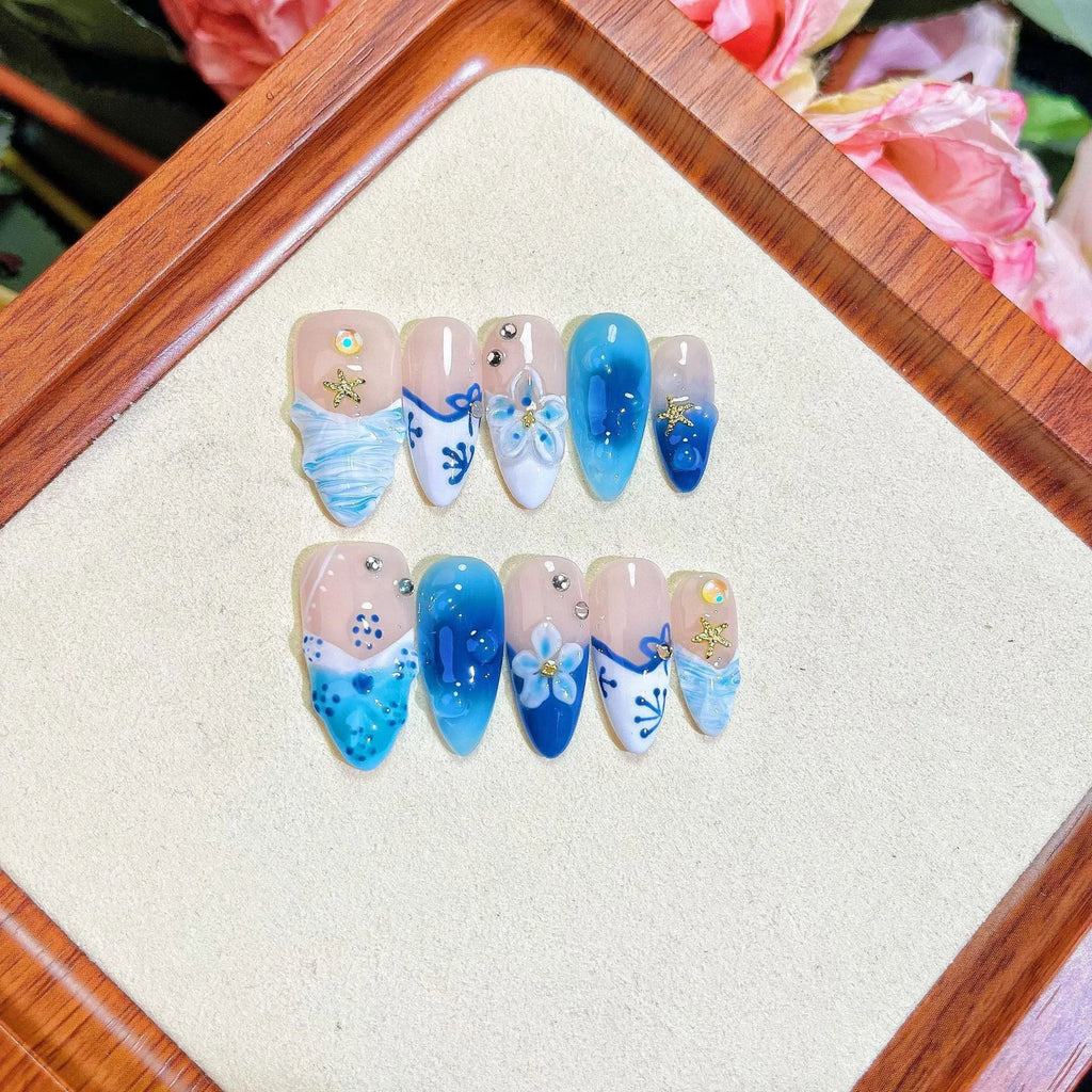 Blue hand-painted carved fake nails with summer ice patterns, transparent sections showing natural nails, four size options displayed
