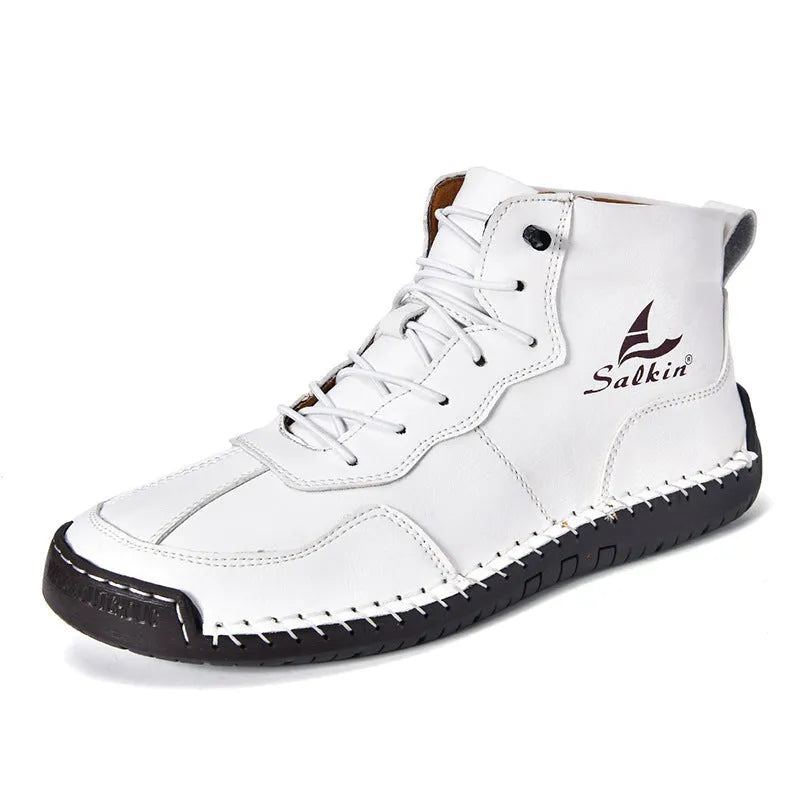 A pair of beige retro high-top casual leather boots with a round toe and elastic band fastening on a plain background.