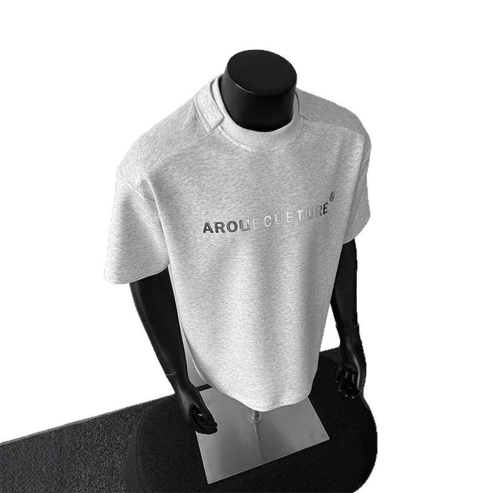 Men's short-sleeve cotton pullover in light grey with letter pattern, showing loose fit and regular sleeves.