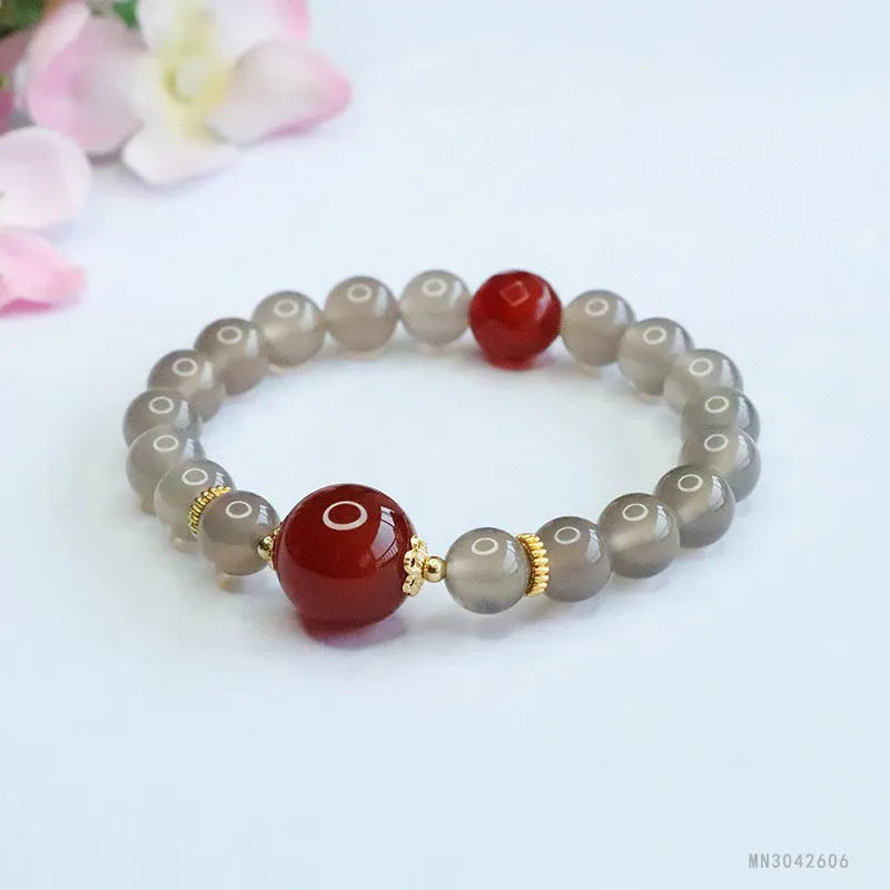 Natural smoky purple and red agate bracelet with 8mm geometric beads on a wrist.